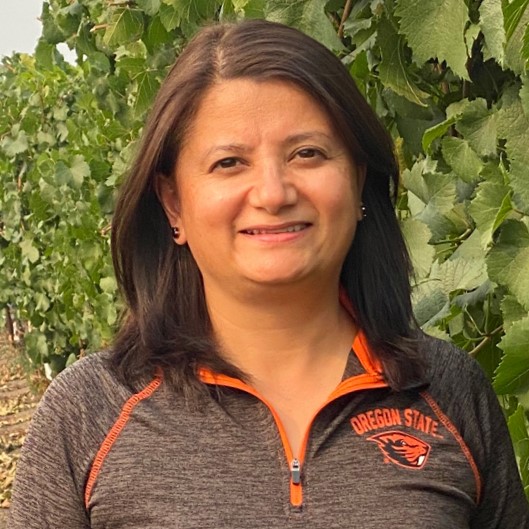 Close up shot of Patty Skinkis smiling in a vineyard