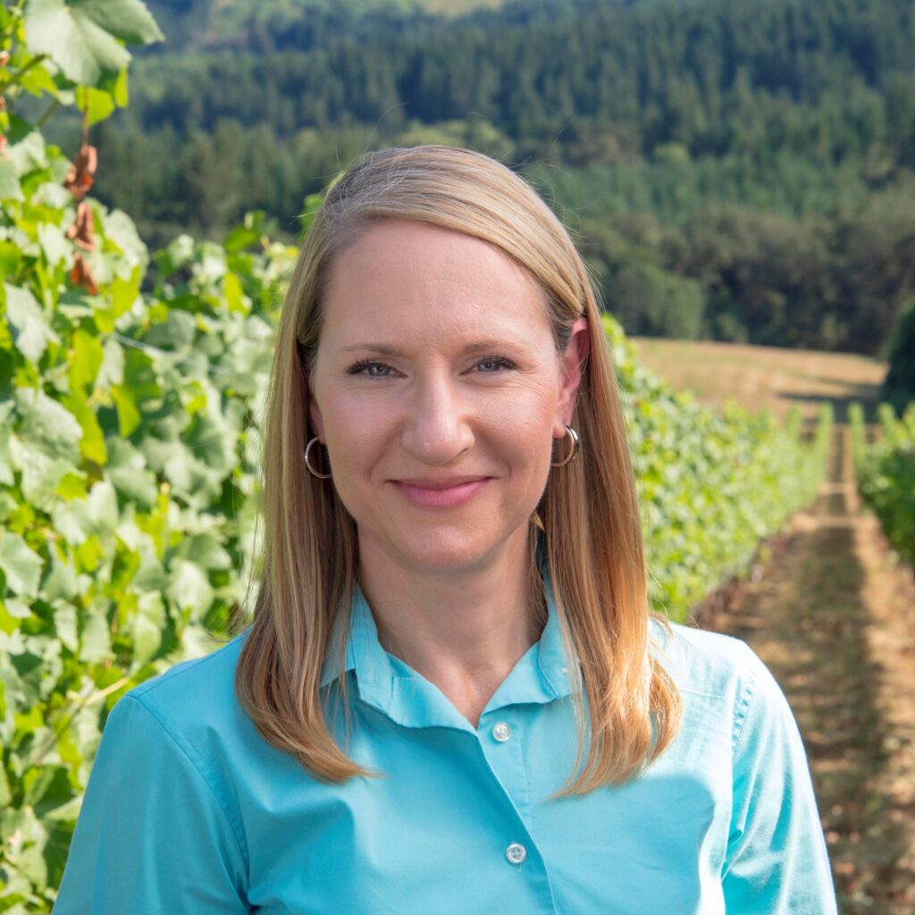 Close up shot of Patty Skinkis smiling in a vineyard