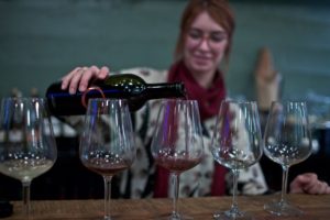 person pouring wine into a glass